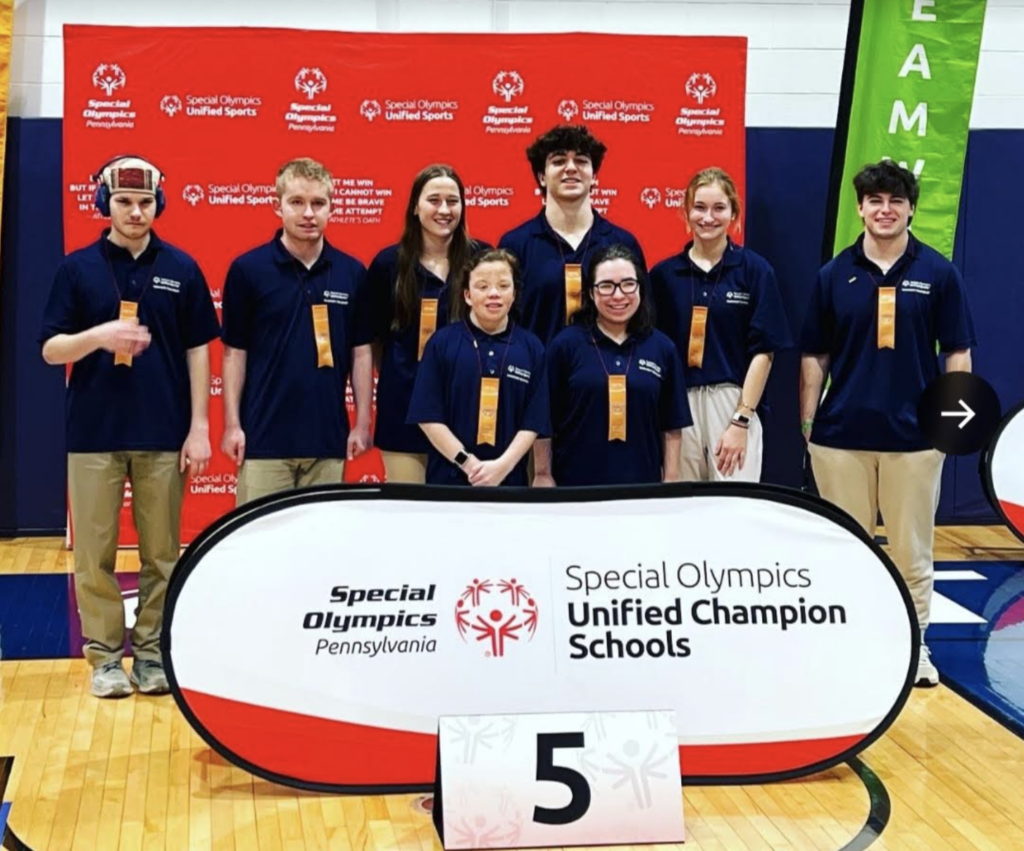 Special Olympics Bocce Team posing behind a sign